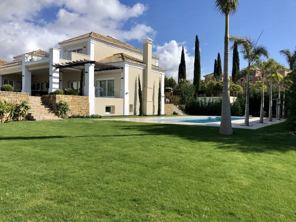 Jardín de villa en Marbella con piscina, pradera y palmeras